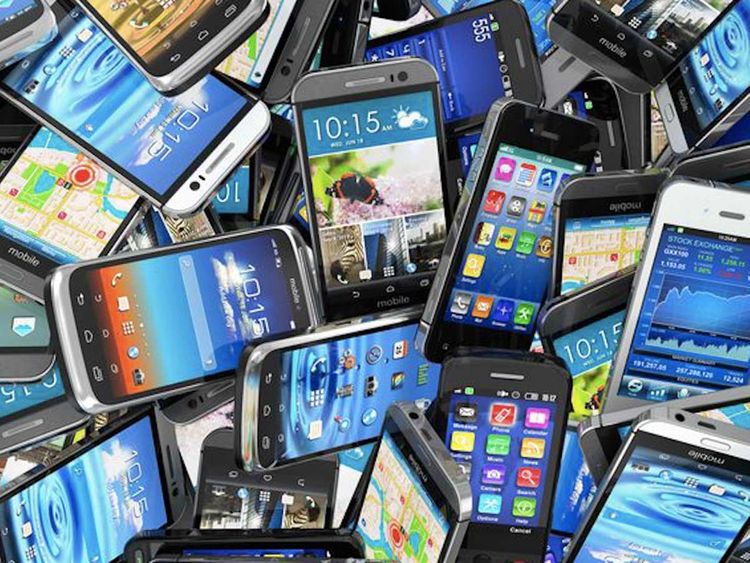 Image of a stack of mobile phones. Various models and brands are present, creating a colorful and diverse array.